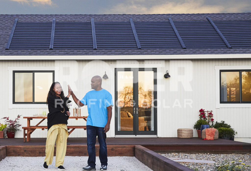 Happy couple high-fiving outside modern home with solar panels on roof