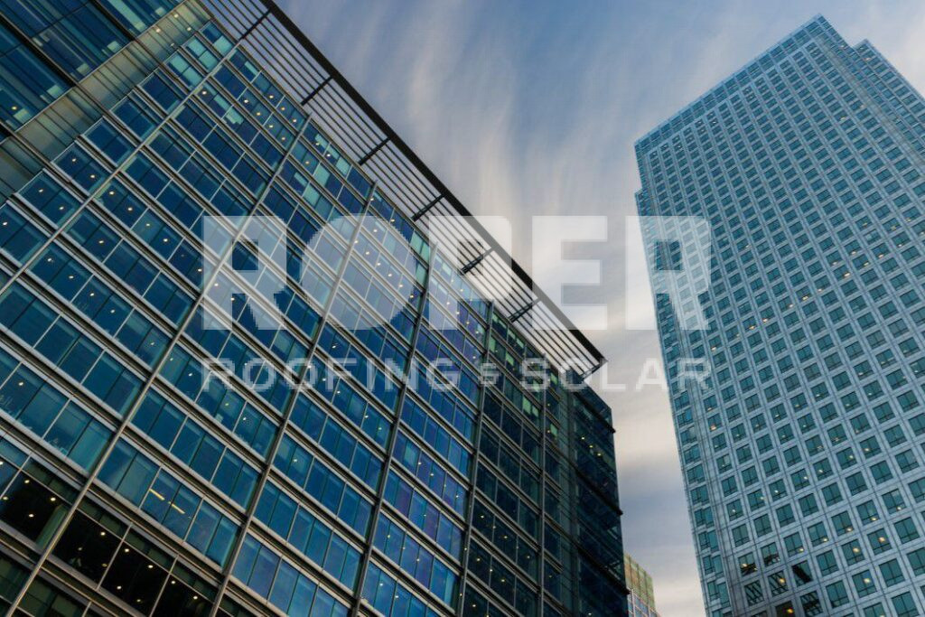 Modern glass office buildings photographed from low angle against cloudy sky